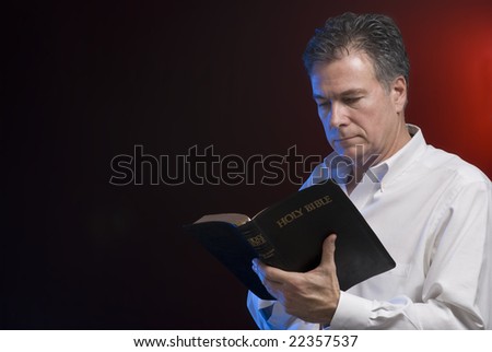 A Man Reading A Bible, Background And Side Lighting With Red And Blue 