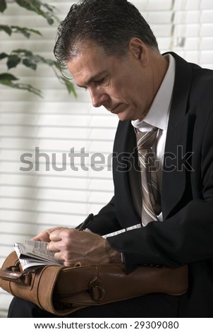 An unemployed white collar worker searching through the want ads.