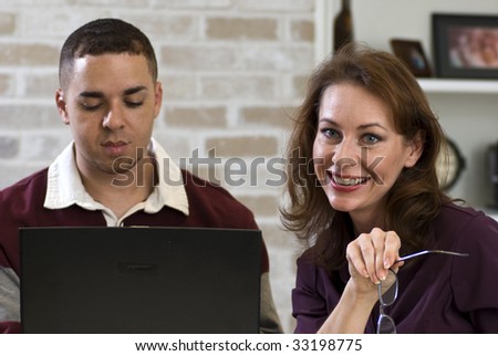 Two young adults using a computer to work on a team project or do research.