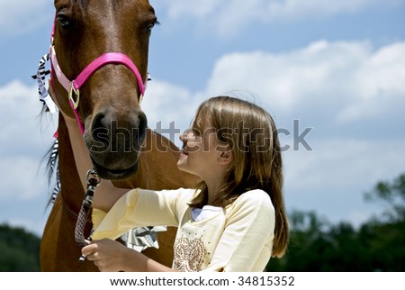 A little girl who is looking with glee at a horse that has been given to her for her birthday.