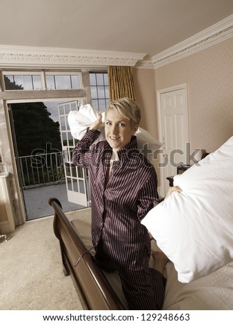 Beautiful girl in pyjamas ready for a pillow fight