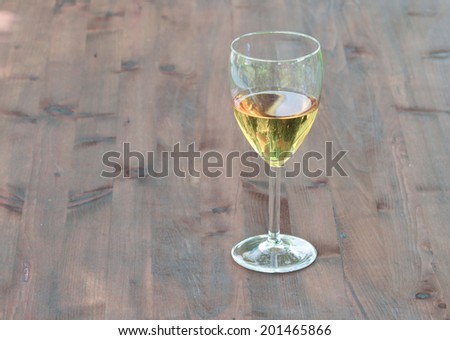 glass of white wine on board old natural wood