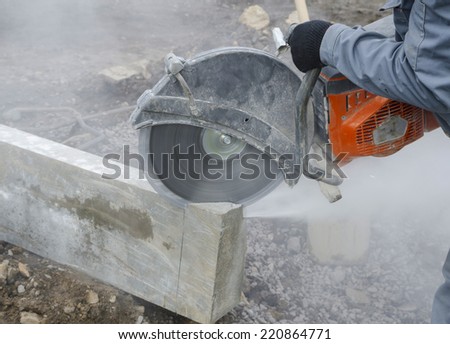 Worker cutting stone block by cutter machine.