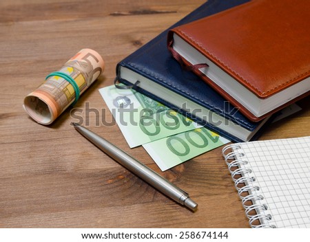 Money, notepad and pen on the table