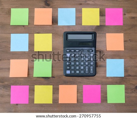 calculator and  multi colored stickers on old wooden table