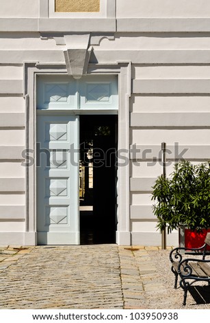 white door wing is left open into a courtyard
