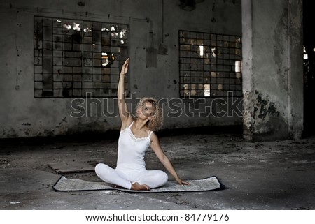 Beautiful blond woman exercises in an abandoned house