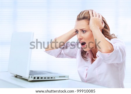 Computer problems / Woman holding her head and screaming at her laptop