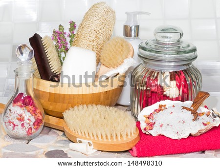Bathing accessories for a luxury spa treatment with body brushes, soaps, marine bath salts and scented dried rose petals