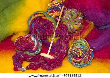 Handmade art yarns made with a handspindle on a colourful wool felt