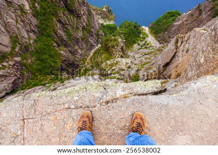 Man standing on cliff Preikestolen in fjord Lysefjord - Norway - nature and travel background