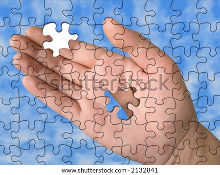 Hand from puzzle without one piece (it layz on 	palm), sky background