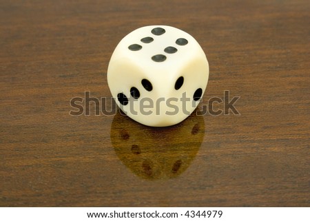 Dice (six) with reflection on wooden table