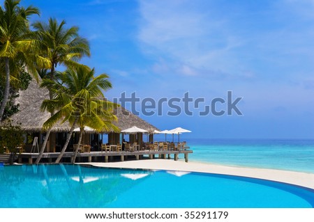 Cafe and pool on a tropical beach - travel background