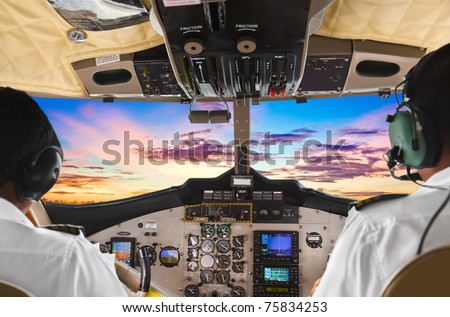 Pilots in the plane cockpit and sunset