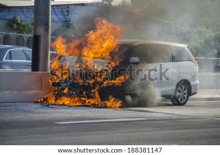 Car bursts into flames on a busy street.