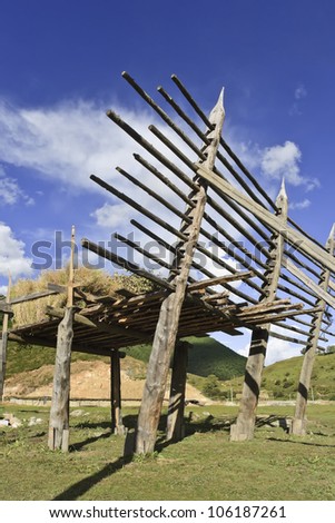 Barley drying on wooden rack on Tibetan style farm in countryside near Zhongdian