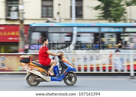 XIANG YANG-CHINA-JULY 1, 2012. Woman on an electric bike on July 1, 2012 in Xiang Yang. Electric bikes are swarming on the streets in China. Nationwide, there are about about 120 million of them.