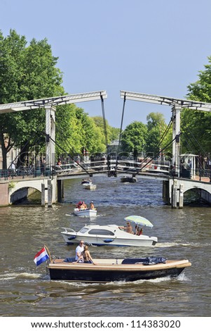 AMSTERDAM-AUG. 19: Boats with drawbridge on Aug. 19, 2012 in Amsterdam. It is known as Venice of the North, it has 1,200 bridges and 165 canals. Best way to experience is one of the boat tours.