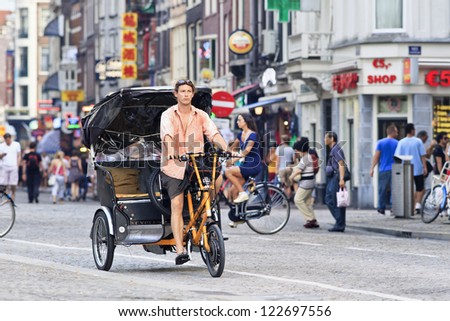 AMSTERDAM-AUG. 19. Rickshaw at Dam square. 38% of traffic movement in A\'dam is by bike, 37% by car, 25% by public transport. In the center, 57% of traffic movement is by bike. Amsterdam, Aug. 19, 2012