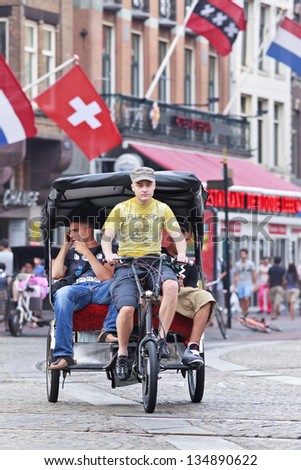AMSTERDAM-AUG. 19. Rickshaw at Dam square. 38% of traffic movement in A\'??dam is by bike, 37% by car, 25% public transport. In the center, 57% of traffic movement is by bike. Amsterdam, Aug. 19, 2012