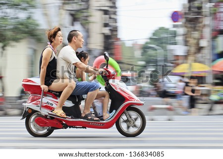 XIANG YANG-CHINA-JULY 3. Chinese couple with their child on a scooter. Chinas family planning policy officially restricts married, urban couples to having only one child. July 3, 2012, Xiang Yang