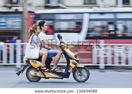 XIANG YANG-CHINA-JULY 1. Chinese young couple on an electric bike. Electric bikes are swarming on the streets in China. Nationwide, there are about 120 million of them. July 1, 2012 Xiang Yang