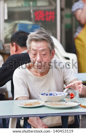 BEIJING-MAY 21. Old Chinese man eats outside. China\'s elderly surpasses 200 million in 2014, top 300 million by 2025. By 2042, more than 30% of China\'s population ages over 60. Beijing, May 21, 2008.
