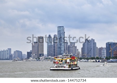SHANGHAI-JUNE 6. Tour boat on Huangpu River. Shanghai port overtook in 2010 Singapore port to become the world\'s busiest container port. SH port handled 29.05 million TEUs. Shanghai, June 6, 2013.