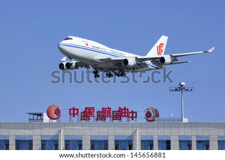 BEIJING-JULY 5. Air China Cargo Boeing 747-412BCF, B-2453 skims over China Aviation Oil Corp. building. All freight version of the 747- 400, wing design of passenger versions. Beijing, July 5, 2013.