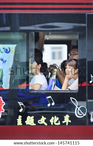 CHANGCHUN-CHINA-JULY 8. Dreamy girl listening to music on the bus. Although heavily congested cities, the most popular transport mode among Chinese commuters is still the bus. Changchun, July 8, 2013.