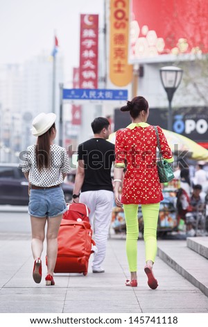 CHANGCHUN-CHINA-JULY 8. Fashionable youngsters in city center. Because of the ongoing prosperity and westernization, fashion is on the minds of China's young urban generation. Changchun, July 8, 2013.