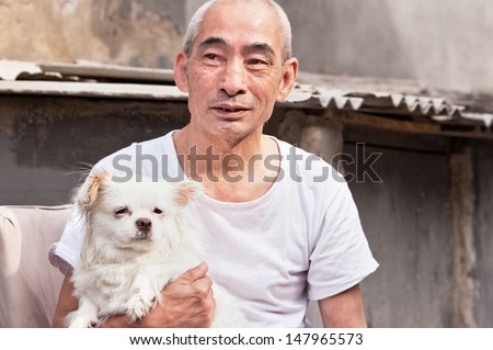 BEIJING-MAY 19, 2011. Old Chinese man with his beloved dog. China\'s elderly population (60 or older) is about 128 million, one in every ten people, the largest in the world. Beijing, May 19, 2011.