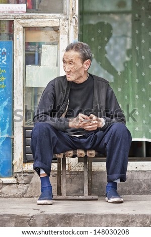 BEIJING-SEPT. 28. Chinese elderly sits in front of his house. China\'s elderly population (60 or older) is about 128 million, one in every ten people, largest in the world. Beijing, Sept. 28, 2007.