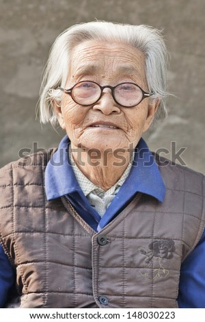 BEIJING-MAY 21. Old Chinese woman with glasses. China\'s elderly surpasses 200 million in 2014, top 300 million by 2025. By 2042, more than 30% of its population ages over 60. Beijing, May 21, 2008.
