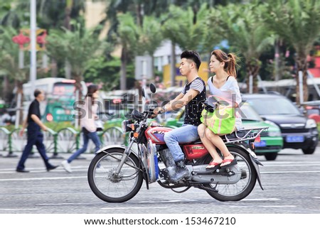 ZHUHAI-CHINA-SEPT. 5. Couple on a Chinese motorcycle. Chinese motorcycle industry has exploded in recent years. The production exceeds 10 million per year and is growing quickly. Zhuhai, Sept. 9, 2013