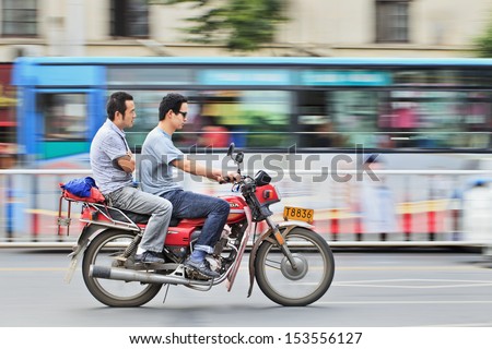 XIANG YANG-CHINA-JULY 1. Two men on a gas motorcycle. Demand for gas motorcycles in China increases primarily in rural areas because of urban bans and restrictions. Xiang Yang, July 1, 2012.