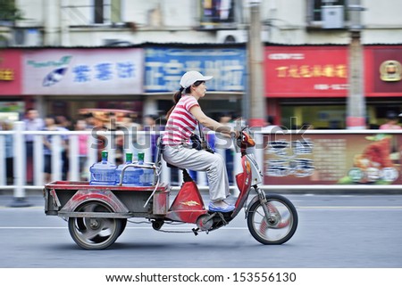 XIANG YANG-CHINA-JULY 1. Woman on an electric freight bike. Electric bikes are swarming on the streets all over China. Nationwide, there are about 120 million of them. Xiang Yang, July 1, 2012.