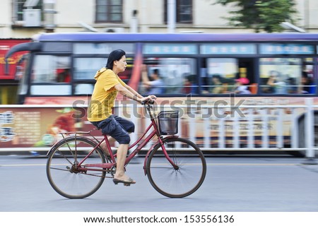 XIANG YANG-CHINA-JULY 1. Woman on a bicycle in Xiang Yang. 430 million owners of bicycles in China represent the biggest increase of individual mobility of the human history. Xiang Yang, July 1, 2012.