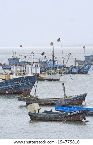 WEIHAI-CHINA-DEC. 2. Moored vessels in a snow shower. Weihai, Shandong Province, has a semi-tropical monsoon climate with hot humid summers and cold dry winters. Weihai, December 2, 2006.