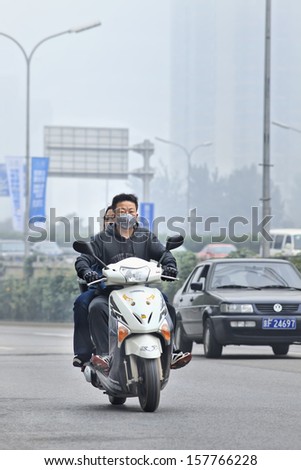 BEIJING- OCT. 6. Man on a scooter wear a mouth cap as smog protection. Monitoring at US embassy showed the Beijing air has been very unhealthy or hazardous first week October. Beijing, Oct. 6, 2013.