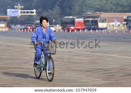 BEIJING-JUNE 1. Young worker on his bike in the early morning. China and US has set legal working age at 16, both have minimum wages laws, and unemployment insurance benefits. Beijing, June 1, 2013.