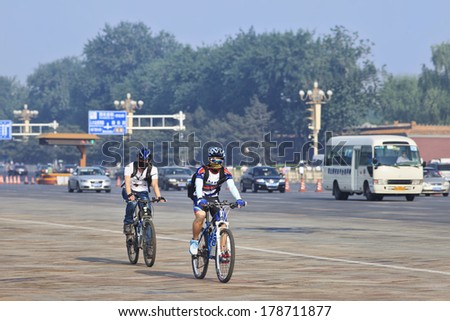 BEIJING-JUNE 1, 2013. Two commuters on mountain bikes with smog protection. The US Embassy measures the Beijing air often as very unhealthy and even hazardous; smog protection became a must.