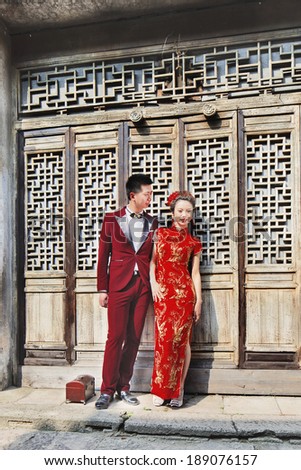 HENGDIAN-CHINA-APRIL 14, 2014. Chinese models pose for wedding photography against ancient wooden construction. Weddings is big business in China, brands compete for share in an $80 billion industry.