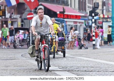 AMSTERDAM-AUG. 19, 2012. Adventurous man on a mountain bike. 38% of traffic movement in the city is by bike , 37% by car, 25% by public transport. In the center, 57% of traffic movement is by bike.