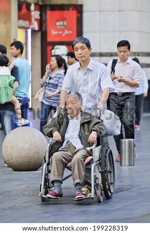 SHANGHAI-JUNE 5, 2014. Disabled Chinese elderly in a wheel chair. The population of the elderly (60 or older) in China is about 128 million, one in every ten people, which is the largest in the world.