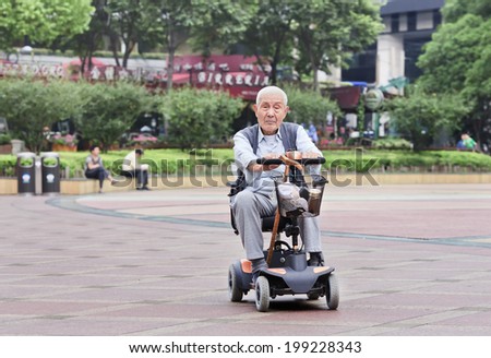 SHANGHAI-JUNE 4, 2014. Chinese elderly in an electric mini car. The population of the elderly (60 or older) in China is about 128 million or one in every ten people, which is the largest in the world.