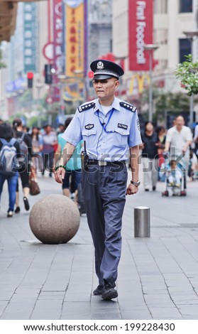 SHANGHAI-JUNE 4, 2014. Police officer in city center. Intensified security in various Chinese cities, especially in the wake of three recent terrorist attacks at railway stations, is widely noticed.