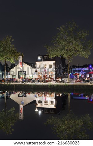 TILBURG-HOLLAND-SEPT. 5, 2014. Pius harbor with cafe and people at night. It is a former industrial area,  near Tilburg center, developed into a lively downtown urban living environment to the water.