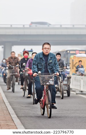 BEIJING-OCT. 11 ,2014. Cyclists in smog blanketed city. A concentration of PM2.5, small particles that poses an enormous risk to human health, hit 462 according the U.S. pollution monitor in Beijing.